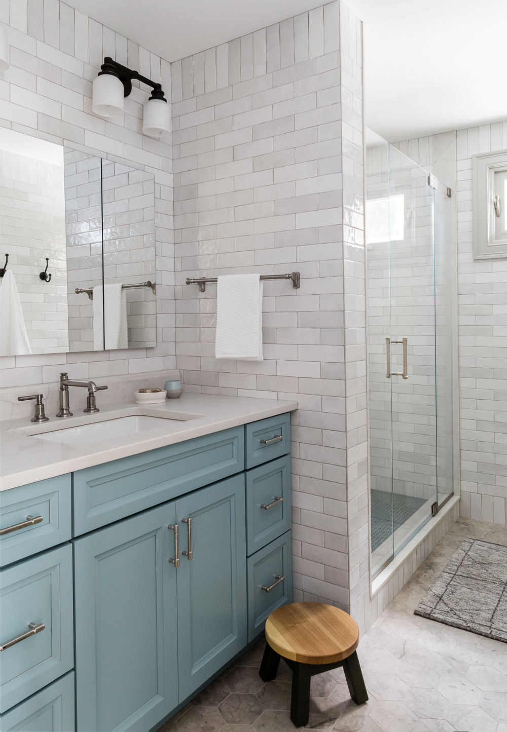 Melrose bathroom remodel with Robin's Egg Blue vanity and floor-to-ceiling tiles.