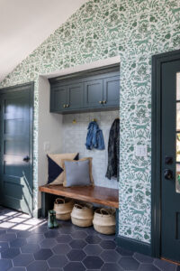 Mudroom with green cabinetry and whimsical wallpaper