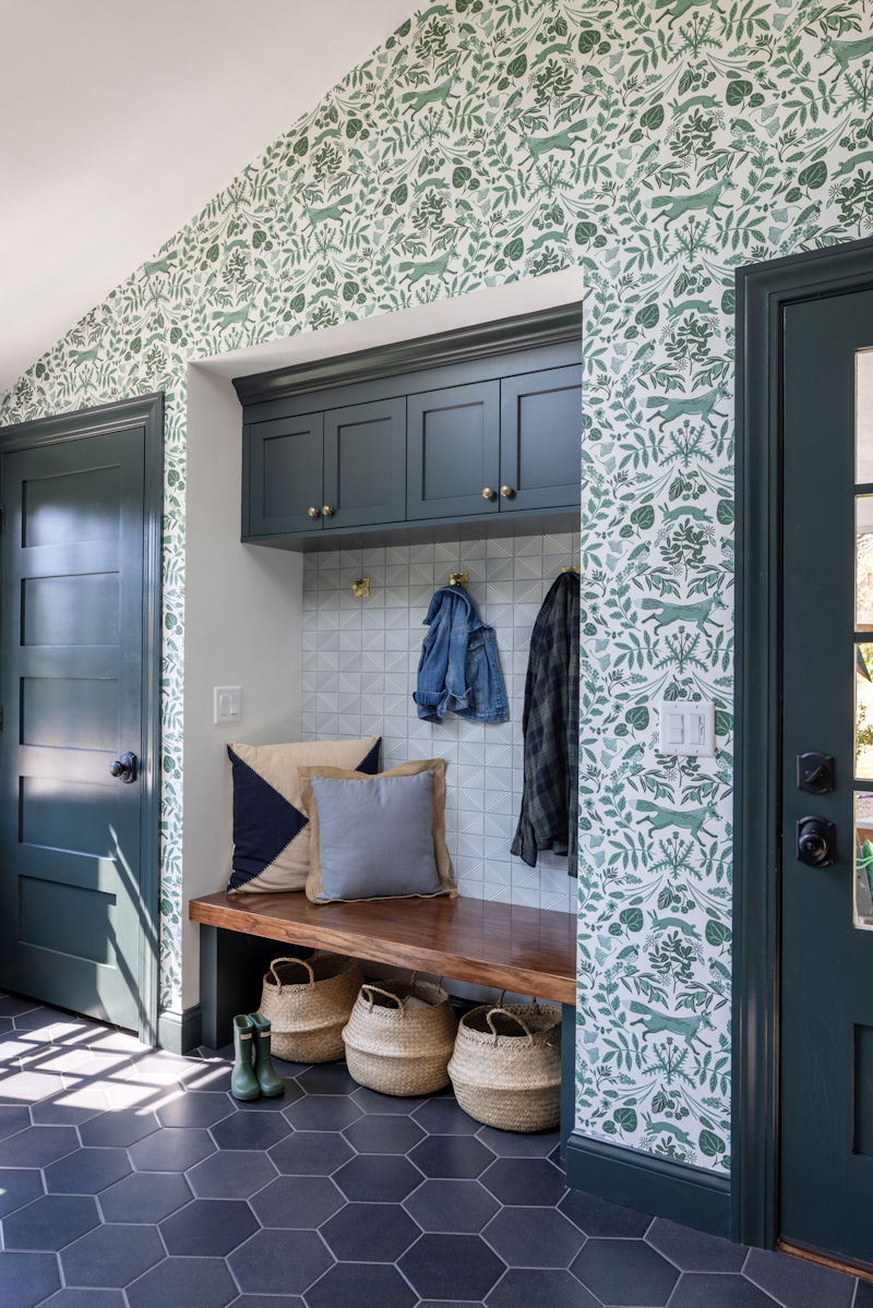 Mudroom with green cabinetry and whimsical wallpaper